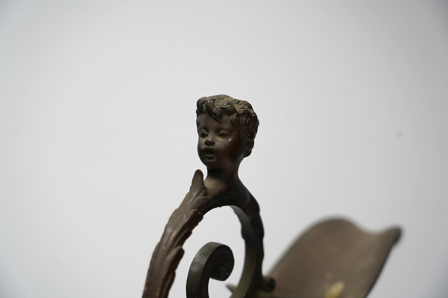 A Cellini style bronze ewer, possibly converted to a lamp later, decorated with putti panel and head handle, 42cm high. Condition - fair to good